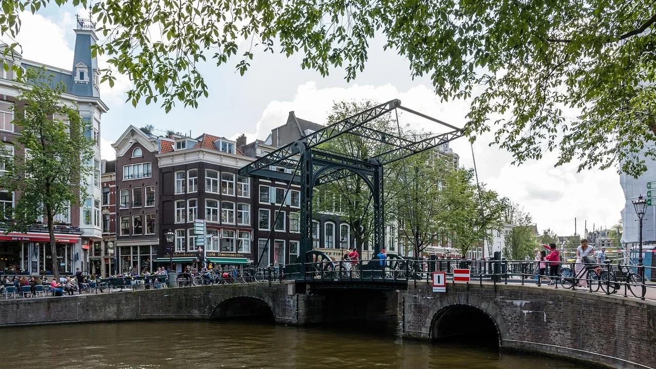 Bicycle parked on a brick canal bridge in Amsterdam