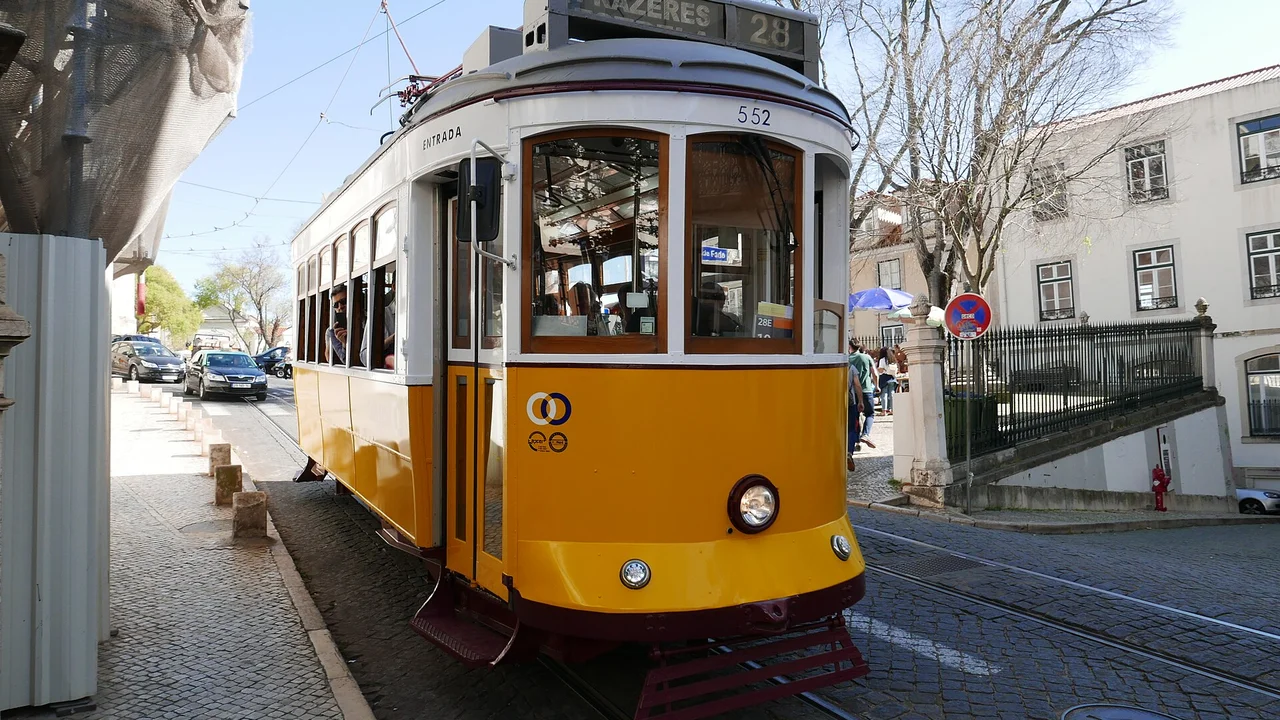 Yellow Tram 28 on a cobblestone street in Lisbon Alfama district
