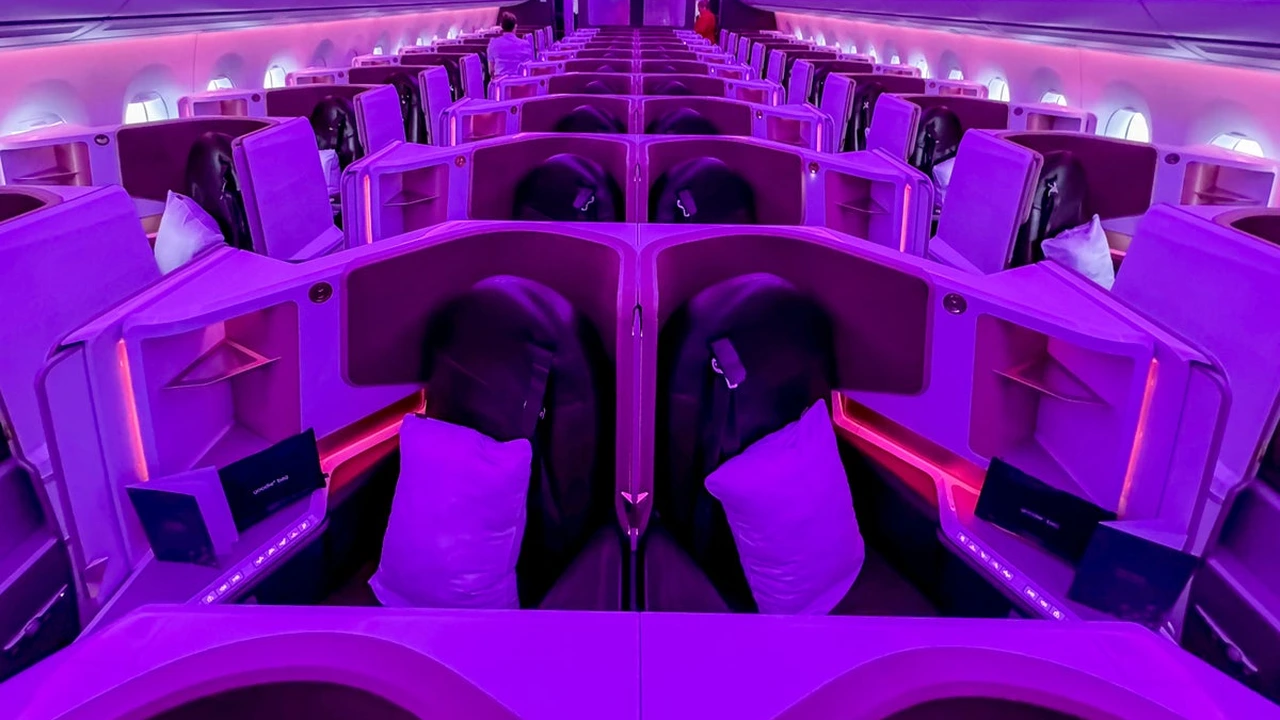 Virgin Atlantic Upper Class cabin with dark grey seats and red accents